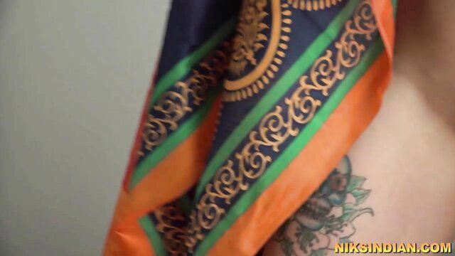 Indian woman with skull tattoo draped in ornate colorful sari