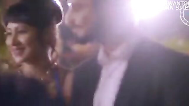 Desi Indian couple in elegant dress suit at night party close embrace