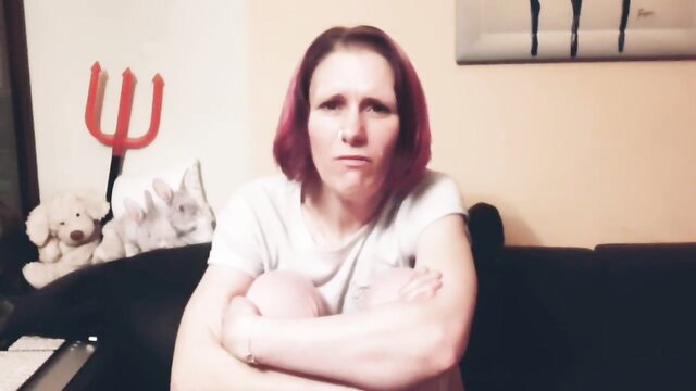 Pink-haired mature woman with arms crossed, annoyed expression