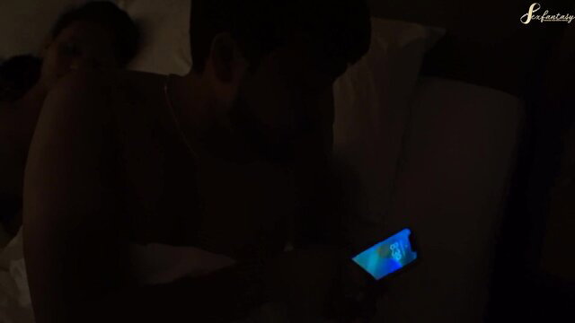 Hot Indian bhabhi in bed at night holding phone with glowing screen