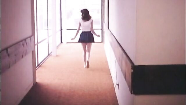Retro blonde teen in sexy school uniform skirt walking in hallway