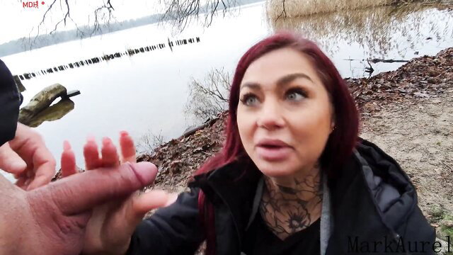 Ria Red sucks cock outdoors by lake with Aurel-Mark