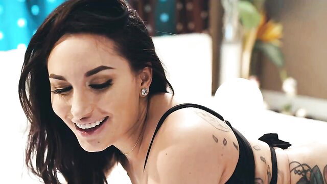 Tattooed Gabi Paltrova smiling seductively in black bikini top