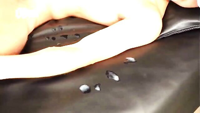 Japanese woman nude on black leather, arm extended, wet drops on surface