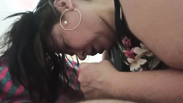 Hot mature Asian lady in floral lei giving intense blowjob closeup
