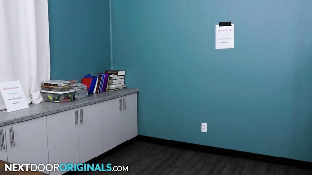 Empty turquoise classroom with teal sign and bookshelves
