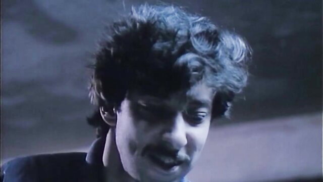 Closeup of male actor with curly hair and mustache in The Female Executioner adult film