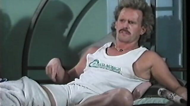 Vintage 1991 hunk in tank top and shorts lounging seductively