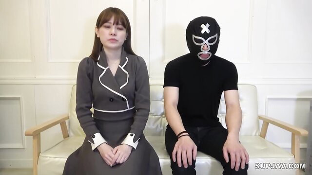 Cute Asian girl in suit with masked man on couch threesome tease