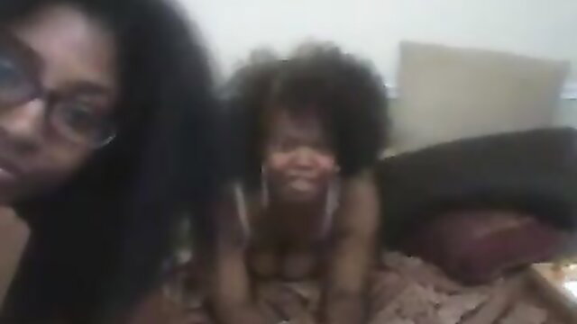 Black mom and toddler girl smiling on bed in amateur home video