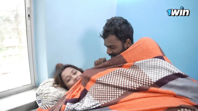 Indian couple cuddles intimately under blanket in morning romance