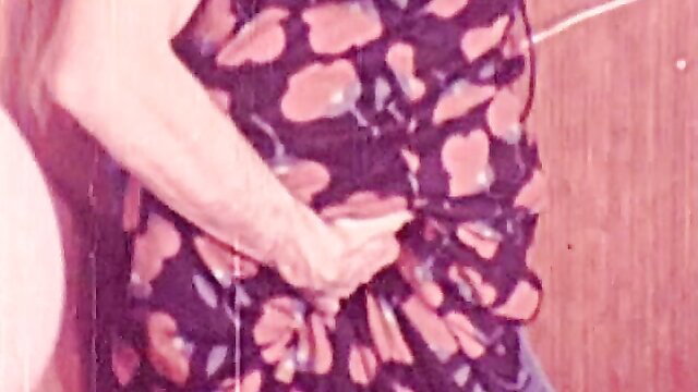 Vintage O.Z. Films New Years Orgy: woman in floral dress holds cock closeup
