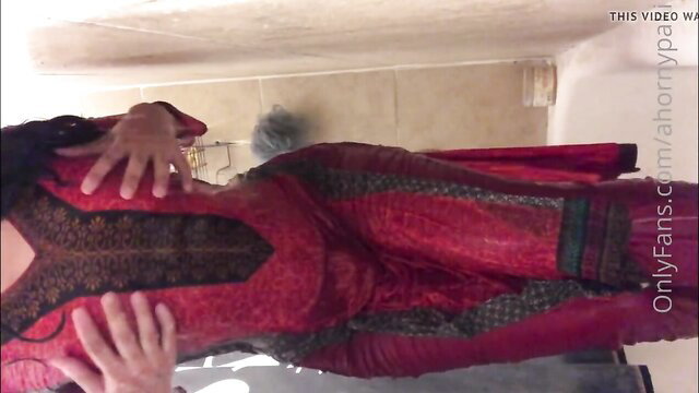 Desi Pakistani babe in red latex dress squeezing tits in bathroom mirror