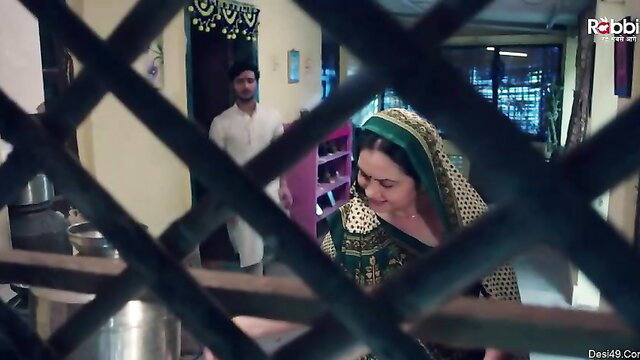 Indian MILF in green saree framed by gate with man, doggy tease