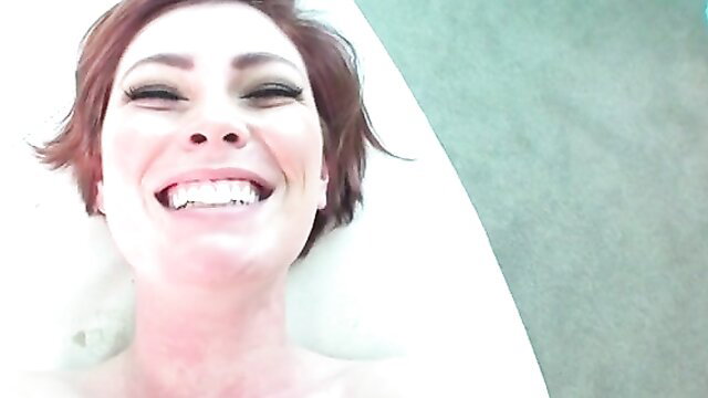 Smiling redhead amateur babe in tub grins for cumshot