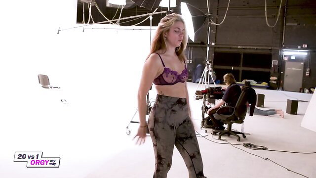 Blonde in purple bra and tie-dye pants poses sexy on Ersties TV gameshow set