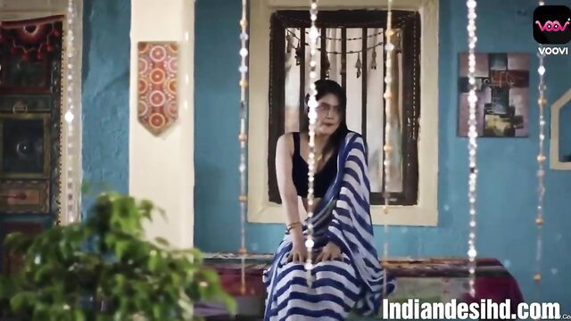 Indian beauty in blue striped saree and black top sits seductively