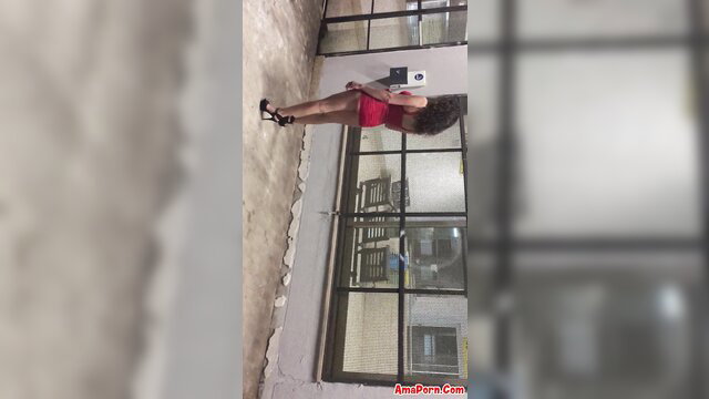Curvy black woman in red dress and heels on night walk at Cannizzaro station