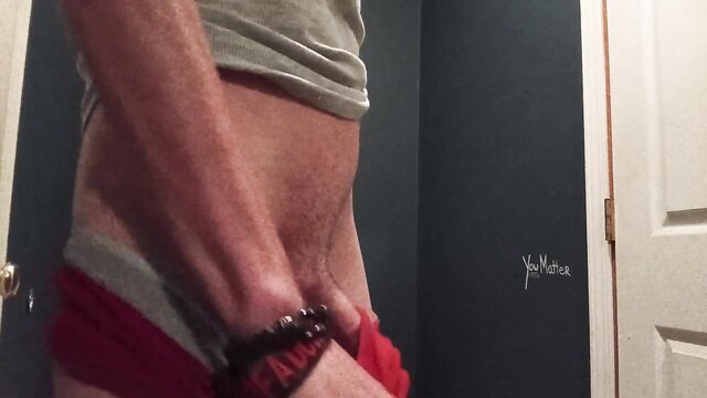 Christopher Anderson bare bisexual dude pulling down red shorts, showing bulge