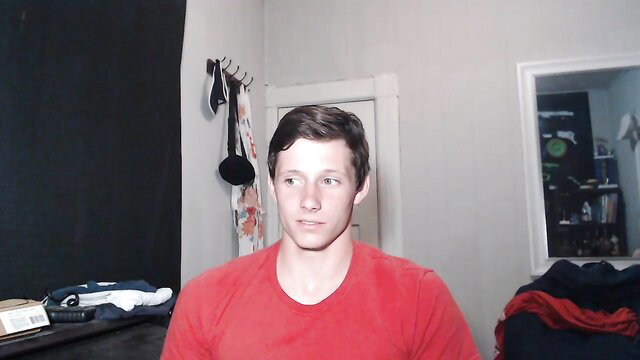 Young twink in red shirt sits ready for gay solo domination cumshot