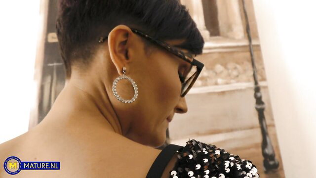 Mature Indian woman with short black hair, big hoop earrings, profile view