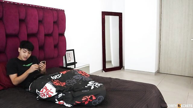 Hanna Miller's stepson lounging on bed in black tee, phone in hand