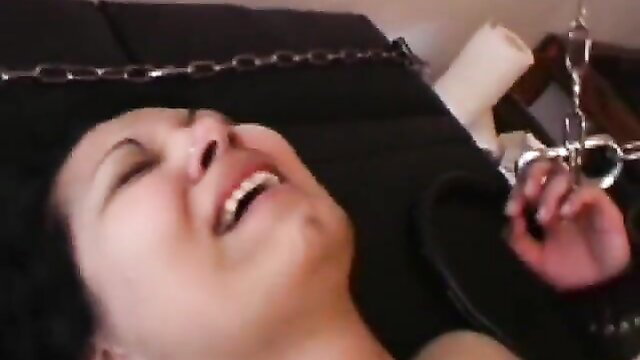 Asian woman bound in chains smiling in bizarre needle torture scene