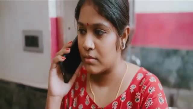 Indian model Kalyanathand on phone in red saree blouse, serious expression