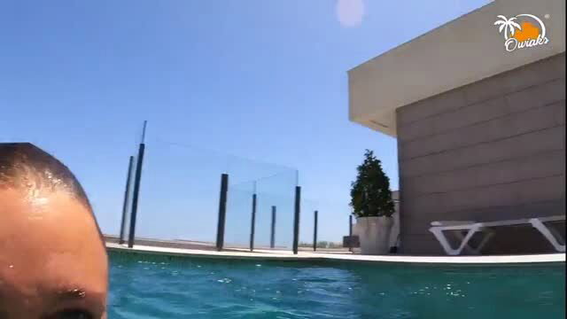 Man in pool selfie, modern villa background