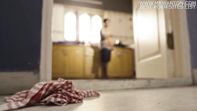 Blurry Indian woman naked in kitchen door, checkered cloth on floor