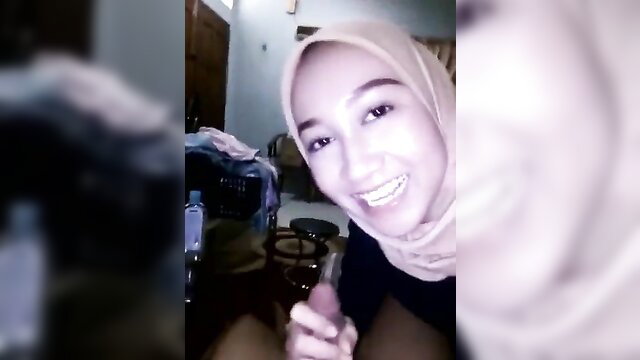Smiling Indonesian hijab babe holds dildo close-up in sensual 4K video