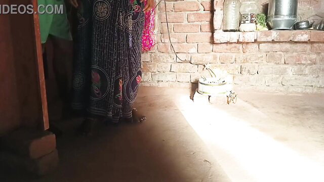Desi Bhabhi in saree stands by kitchen wall, tight coochie ready