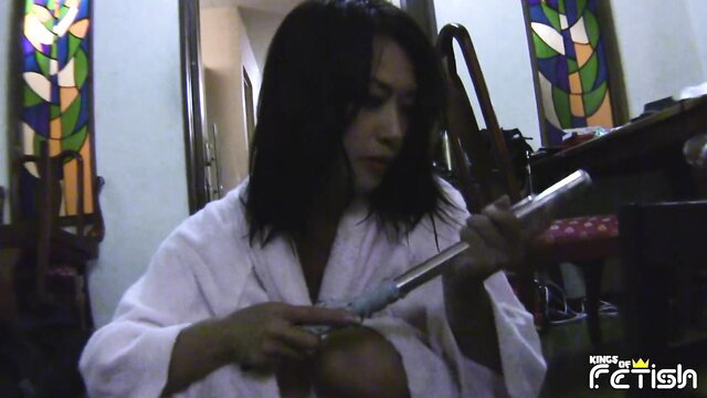 Japanese singer in white bathrobe holds glass dildo, solo tease