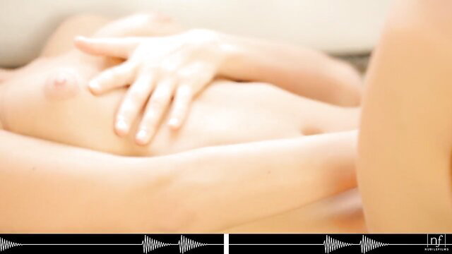 Blonde woman teasing nipples in erotic hands-on-bosom pose
