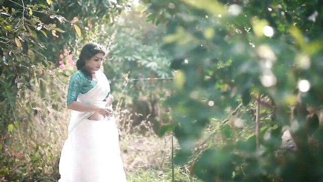 Resmi R Nair in sheer white saree, teasing in lush garden