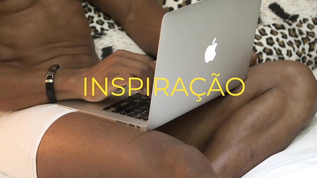 Hot black guy in white briefs typing on MacBook on leopard bed