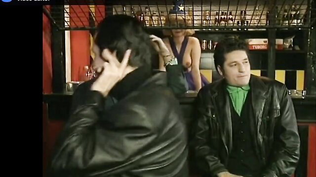 Aleksandra Anđelković in bar with topless blonde bartender, two men watching