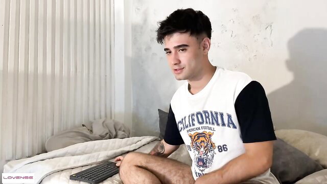 Handsome young Latino guy Zack Sullivan in bed, casual shirt, legs spread