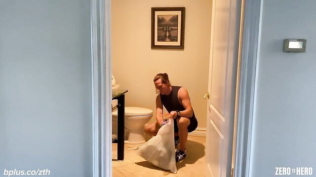 Muscular man squatting in bathroom holding white bag - Siri Dahl Zero to Hero