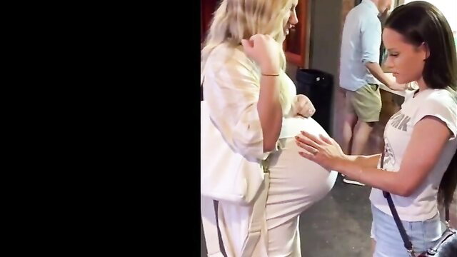 Blonde woman touches brunette's huge pregnant belly in lesbian scene