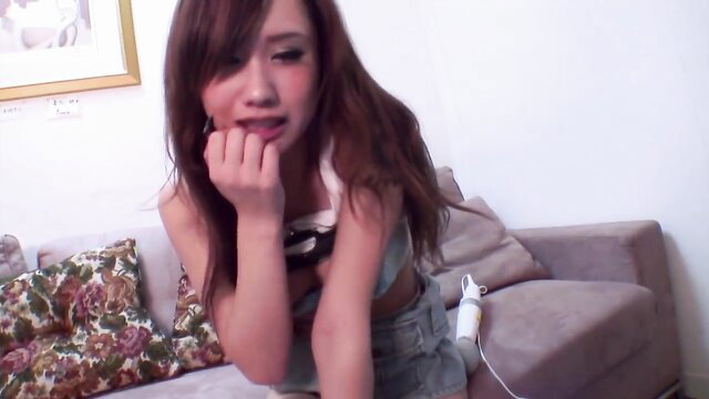 Japanese JAV girl with passion, biting lip seductively on couch
