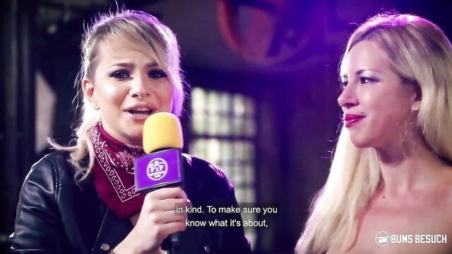 Busty blonde MILFs in leather & bandana on hot interview stage