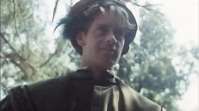 Rocco Siffredi smirks in green tunic hat, vintage adult scene