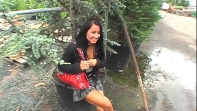 Brunette girl in mini skirt smiling at tree nursery