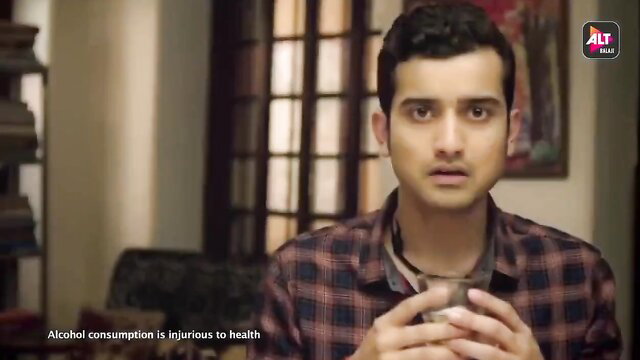 Handsome Indian man in plaid shirt warns alcohol harms health