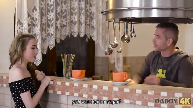 Blonde teen in polka dot dress offers sugar to older man in kitchen