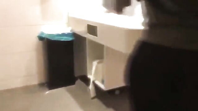 Asian woman in tight pants bending at gym sink, big ass upskirt view