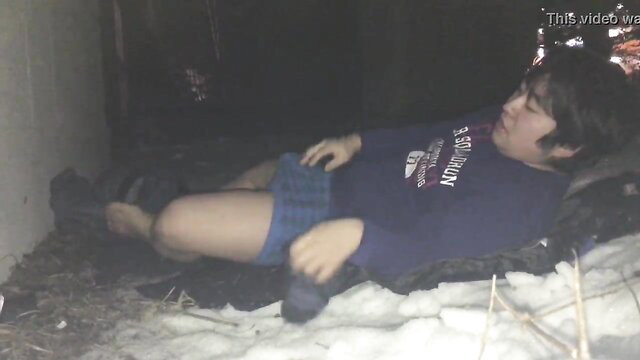 Asian twink sleeping in plaid skirt and hoodie on snowy floor