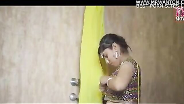 Indian beauty in sparkly blouse and yellow saree poses seductively