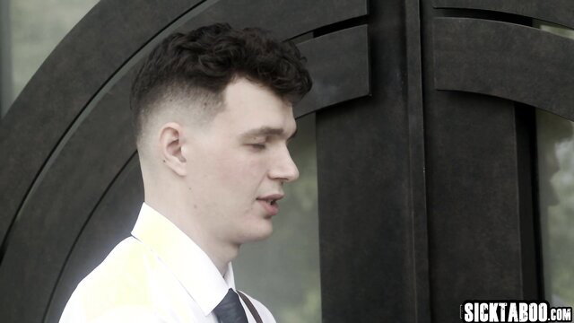 Handsome young man in suit by black gate, SickTaboo watermark